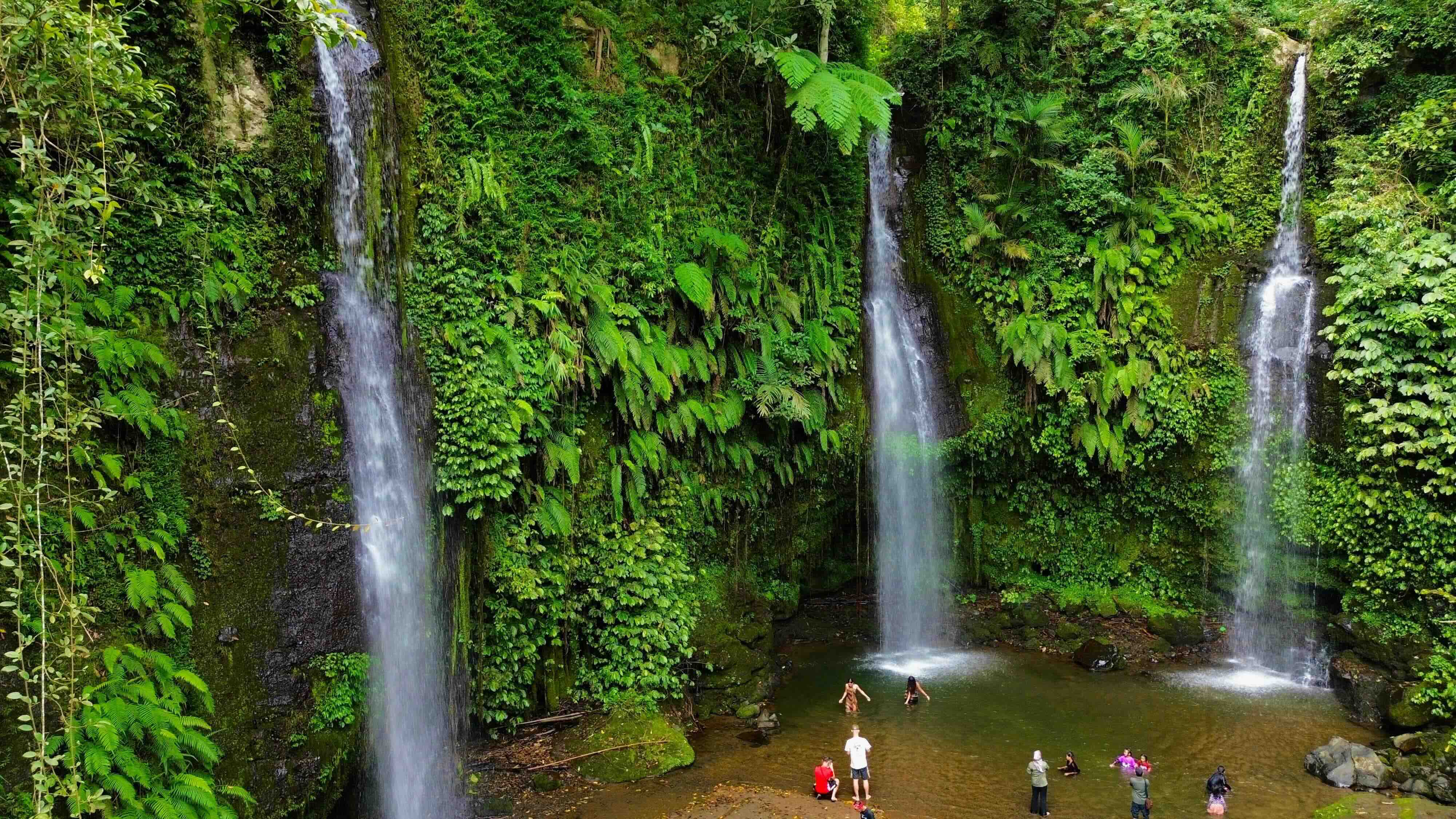 Multiple waterfalls cascading through lush jungle in Tetebatu, Lombok